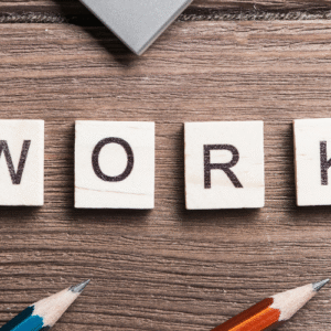 Work spelt out on a desk using tiles with usual work related paraphernalia such as pencils, notepads in shot