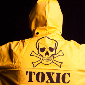 Human with a yellow jacket on and word toxic with the skull and cross bones symbol emblazoned on the back