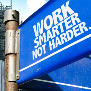 Blue sign saying work harder not smarter on the background of commercial buildings including scaffolding